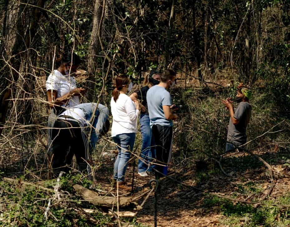 Celeste Lomax shares her knowledge of the food found in the forest with other volunteers.