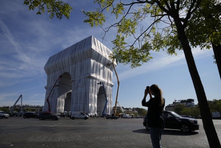 An onlooker takes a picture as workers put the final touch to the ‘L’Arc de Triomphe, Wrapped’ project in September 2021.