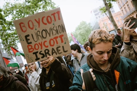 People march as one holds a sign that says ‘boycott Eurovision boycott Israel’
