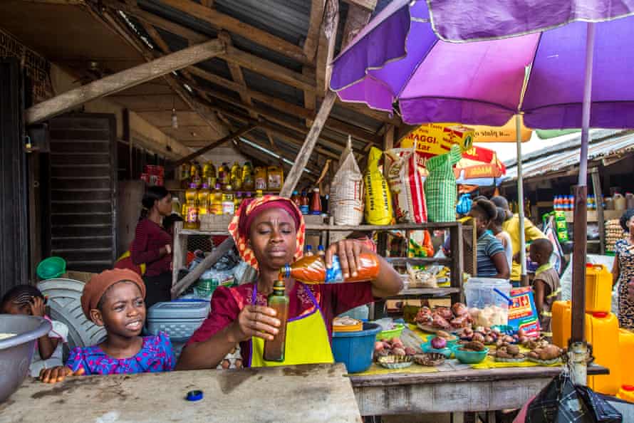 Comfort Oluwatuyi vendant de l'huile de palme dans une épicerie du marché du camp
