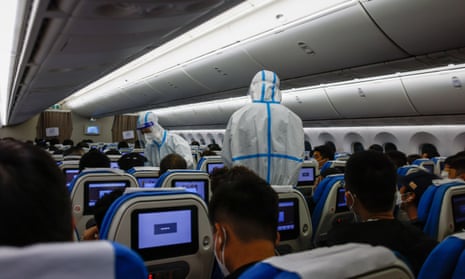 Airline personnel wearing protective suits check passengers on arrival at Xiamen international airport in China's Fujian province last week as Covid infections surge across the country.