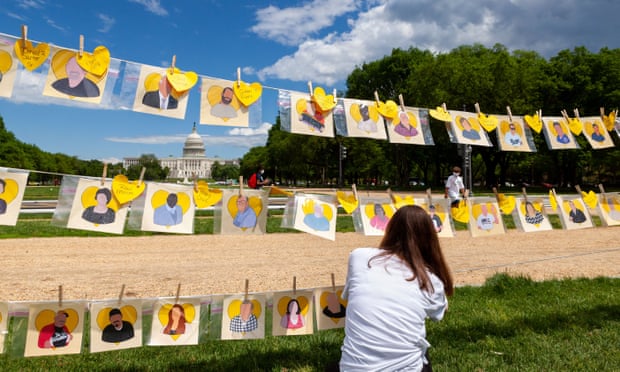 Hannah Ernst, the artist who created the Faces of Covid memorial, hangs names of those lost in the pandemic in Washington DC in May 2021. 