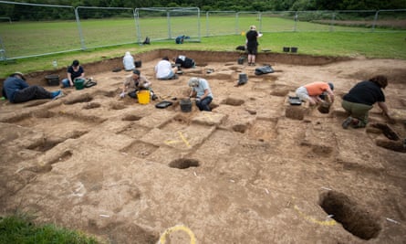 People digging in sandy ground at an archaeological site