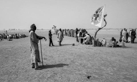 People wait for food distribution by ICRC in Toumour camp where 47 thousand Nigerian refugees and internally displaced Nigerians took shelter in southeastern Niger. 