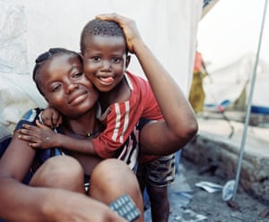 Woman and child embrace in a makeshift shelter