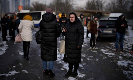 People wait on a street blocked by police after a rocket attack in Kyiv, Ukraine, Thursday, Jan. 26, 2023. (AP Photo/Daniel Cole)