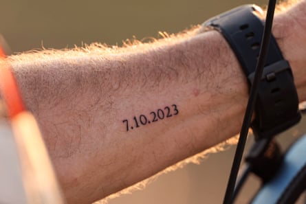 a tattoo on a person’s arm reads ‘7.10.2023’