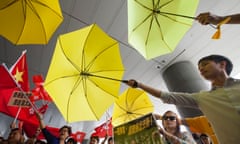 Hong Kong pro-democracy protesters (with yellow umbrellas) clash with government supporters (with red flags) in 2015.