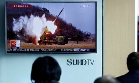 South Koreans watch television news about North Korea’s  tests of ballistic missiles, 18 March 2016.