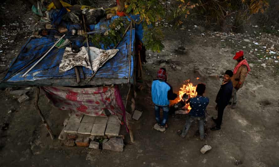 People gather around a campfire to stay alert outside a house in DelhiPeople gather around a campfire to keep warm outside a homeless shelter in Delhi