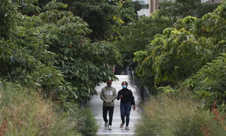 Two people walk down an overgrown path