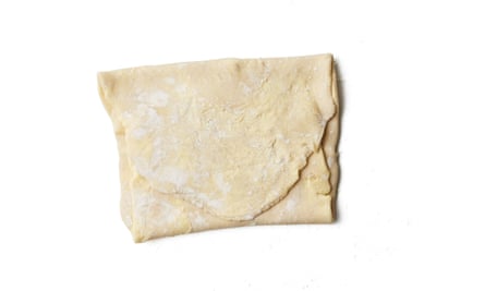 Fold the pastry ‘arms’ over each other so they completely enclose the butter. Roll out the dough rectangle to about three times its original length, then fold the top third down into the middle and the bottom third up over the top.
