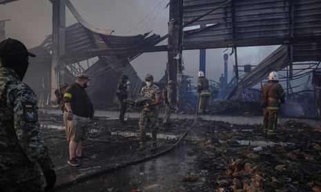 Rescuers and service members work at a site of a shopping mall hit by a Russian missile strike in Kremenchuk, Ukraine.