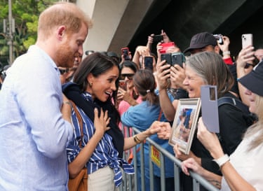 A woman presents Harry with a framed photograph of him with her mother, Daphne Dunn, in Sydney