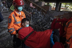 Medics carry a man past debris at Polytechnic University, Hong Kong