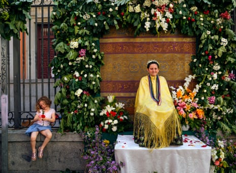 A ‘Maya’ girl sits on an altar during the traditional celebration of ‘Las Mayas’ on the streets of the small village of Colmenar Viejo