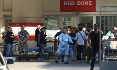 Soldiers, medics and members of the public gathered outside a hospital entrance with the words âRed zoneâ on a board above the door