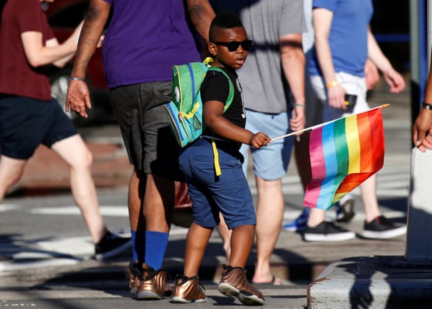 A boy carries a rainbow flag near the Stonewall Inn, on the eve of the LGBT Pride March, in the Greenwich Village section of New York City.