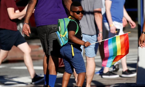 A boy carries a rainbow flag near The Stonewall Inn, on the eve of the LGBT Pride March, in New York City.