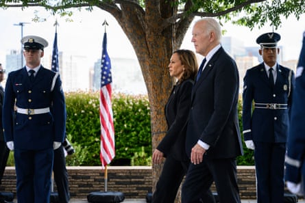 man and a woman walking in front of people in military uniforms