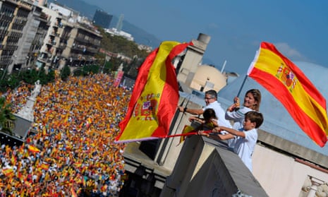 Protesters wave Spanish flags from a balcony during a rally in Barcelona to support the unity of Spain.