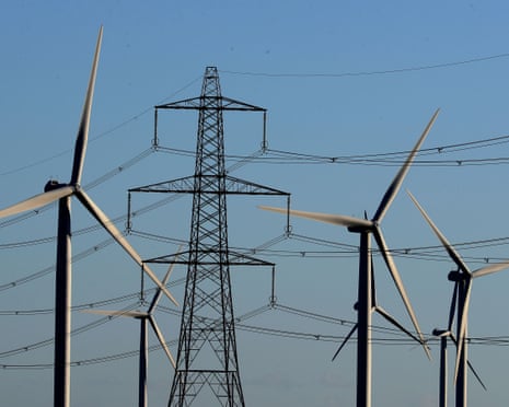 A view of the Little Cheyne Court wind farm amongst existing electricity pylons on the Romney Marsh in Kent.