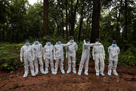 Armed police officers wearing protective equipment prepare to transport bodies to the pit at Devghat mass burial site in Chitwan, Nepal.