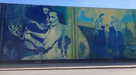A mural of women working on nets, next to another one of women tending babies at the dockside in front of a ship