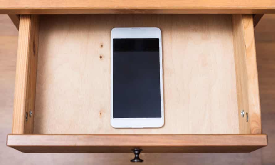 Above view of mobile phone in open drawer