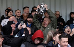 A home fan with a replica trophy