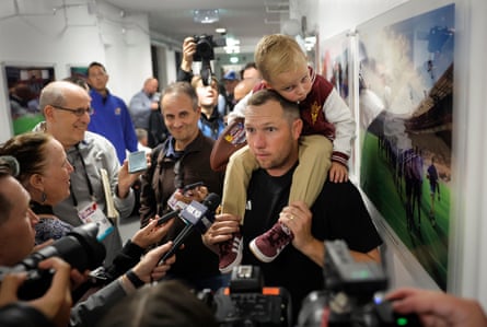 Winning ASU head coach Kenny Dillingham talks to the media in a corridor outside the changing rooms with his 3-year-old son Kent on his shoulders.
