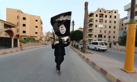 A fighter waves an Isis flag in Raqqa in June 2014