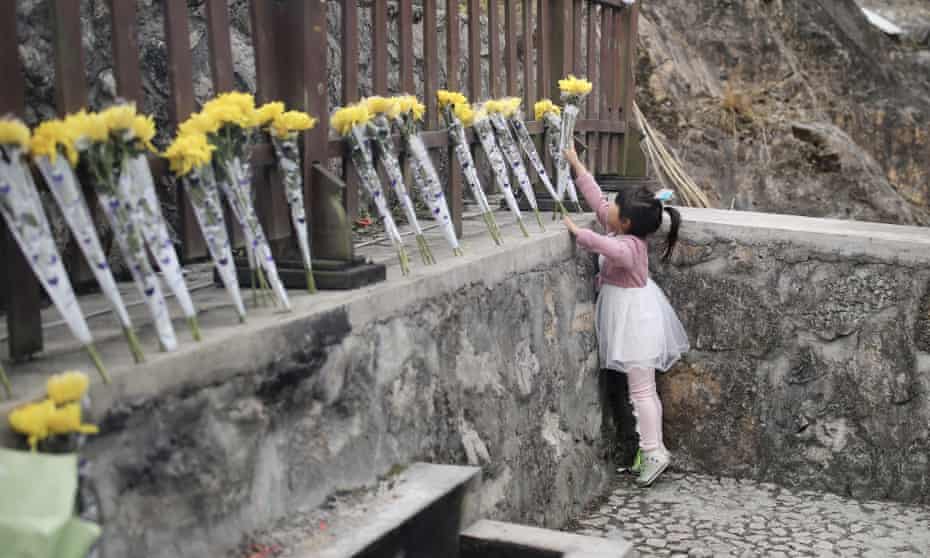 A girl lays flowers to mark the 10th anniversary of the Sichuan earthquake in May 2008 that killed almost 90,000 people in China.