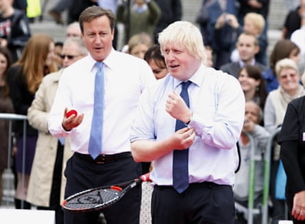 Cameron and Johnson in shirtsleeves and ties, with Johnson rolling his sleeves up and Cameron holding a tennis racket