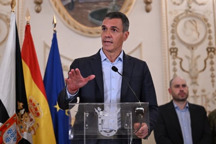 Pedro Sánchez gestures as he speaks into a microphone at a lectern