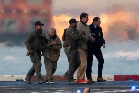 law enforcement officials escort a man and a woman outside