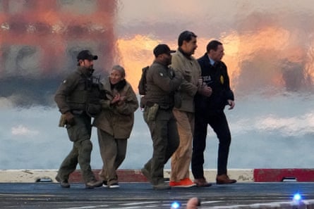 law enforcement officers escort two detained people outside