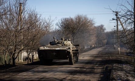 Soldiers drive a BMP armoured vehicle in a village close to the frontline.