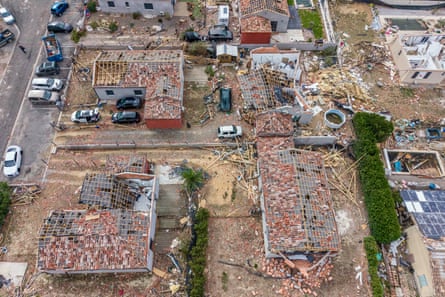 Aerial view of several houses with their roofs ripped off
