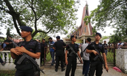 Indonesian mobile brigade policemen stand guard after an attempted suicide bombing at St. Yoseph Catholic Church in Medan.