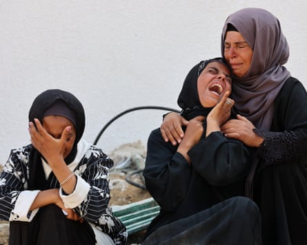 Women cry as they mourn the death of a loved one killed during overnight Israeli bombardment on Gaza City, 12 June 2025.