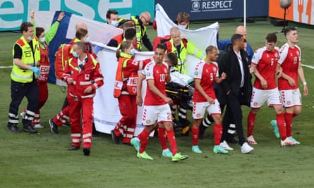 Denmark’s players flank paramedics attending to Christian Eriksen (not seen) after his collapse at the Parken Stadium in Copenhagen on 12 June 2021.