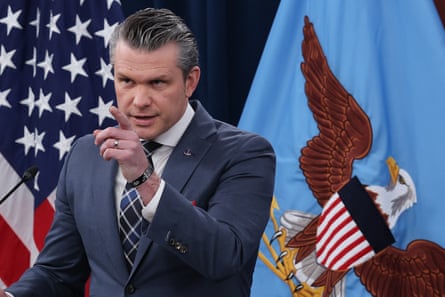 Hegseth pointing with one finger as he speaks in front of a US flag