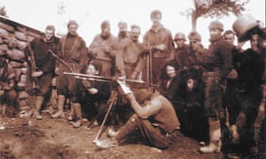George Orwell (the tallest figure) and Eileen Blair, seated in front of Orwell, with members of the Abraham Lincoln Brigade at the front near Huesca, Spain, March 1937.