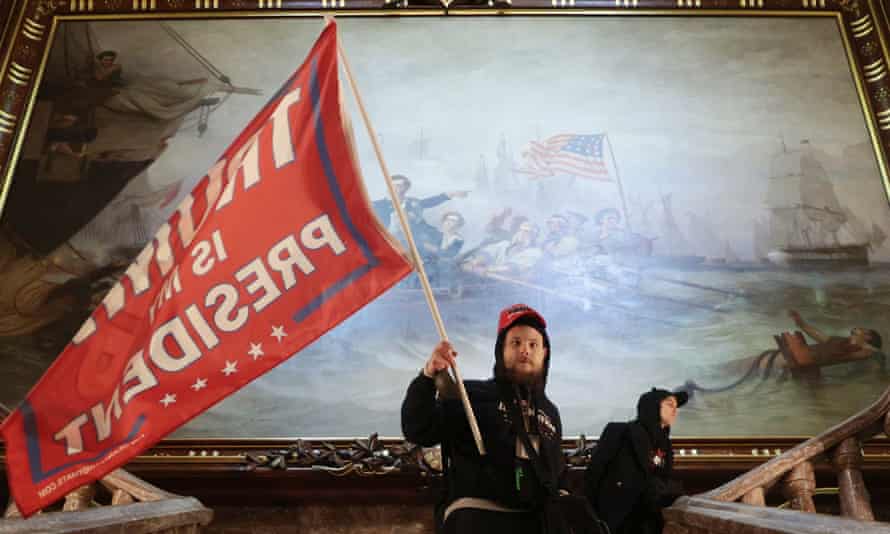 A man holds a Trump flag inside the US Capitol after a pro-Trump mob stormed the building.