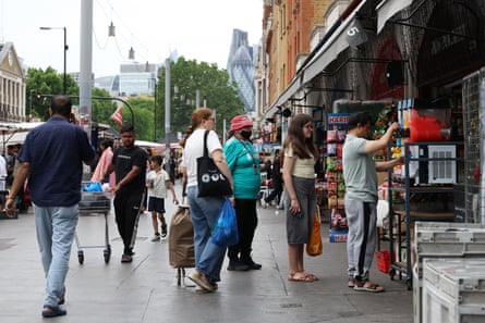 People queue for ice drinks on a high street in London during a heatwave