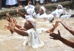 people up to their waists in water, with arms outstretched