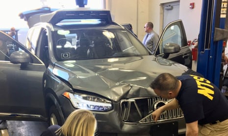 Transport safety investigators examine a self-driving Uber vehicle involved in a fatal accident in Tempe, Arizona.