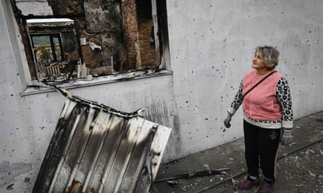 Valentyna Zgonyk-Safonova, 50, looks at her destroyed house