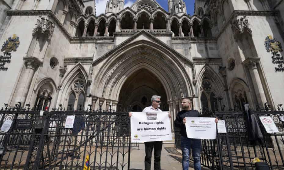 Protestors stand outside the Royal Court of Justice in London.